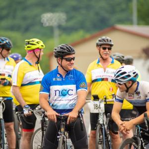 A group of 5 male cyclists wait at the start of the 2019 ride